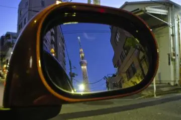 <p>Reflection in a car's side mirror in the bylanes of Oshiage</p>