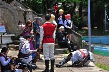 Various groups of cosplayers posing in front of the castle