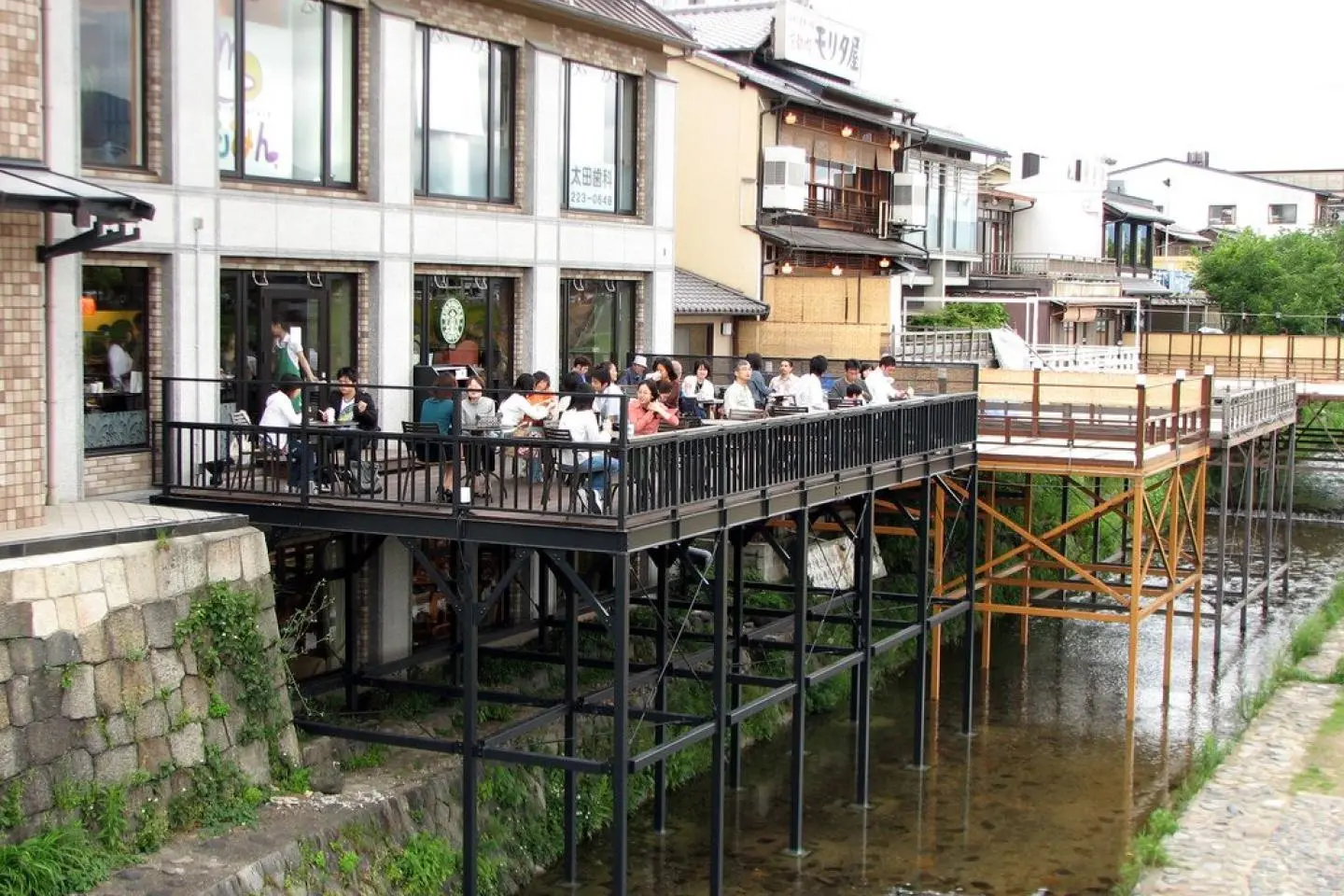 Wooden decking above the Kamo River at this Sanjo Ohashi coffeeshop (Photo présentée par Chris Gladis / CC BY 2.0)