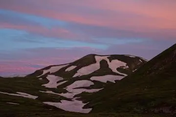 Sunrise light paint the snow in a pastel pink color