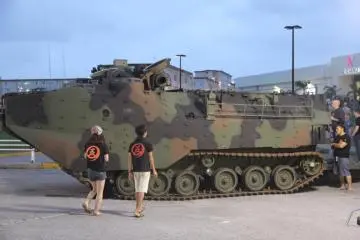 Visitors look at a static display of an advanced amphibious assualt vehicle