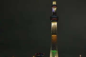 View of Tokyo Skytree behind the glowing blue Sumida River.