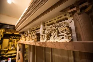 The complex sculptures on an unpainted butsudan.