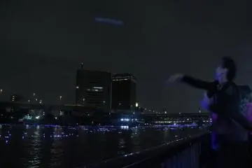 A group of ladies tossing (more like throwing baseball-style) their inori boshi into the river before they leave. The aim seems to be getting it as far as possible – which would explain the baseball-style throwing.