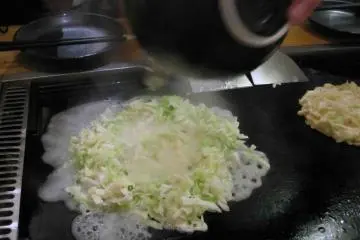 Delicious okonomiyaki being cooked at Sakuratei. For only 2000 yen, enjoy tabehoudai (all-you-can-eat) for 120 minutes!
