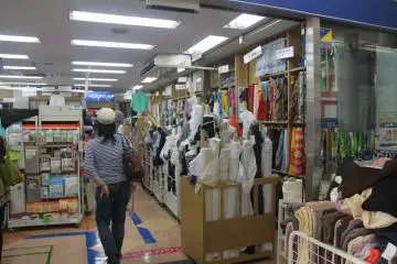 <p>ทางเข้าร้านขายผ้า ขนาดมองจากด้านนอกก็จะเห็นผ้าเป็นแถบ ๆ เยอะมาก</p>