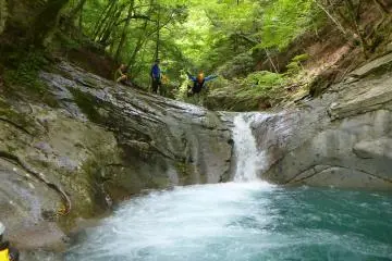Jumping a small waterfall watched by some amused hikers