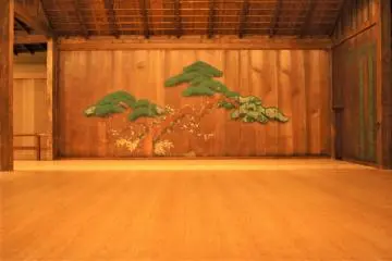 Traditional pine tree design on the noh stage (Photo: <a href="https://commons.wikimedia.org/wiki/File:%E6%A8%AA%E6%B5%9C%E5%B8%82%E8%83%BD%E6%A5%BD%E5%A0%82_%E8%88%9E%E5%8F%B0%E7%B5%B5.JPG" target="_blank" rel="noreferrer noopener nofollow">Yoshi ban / CC BY-SA 3.0</a>)