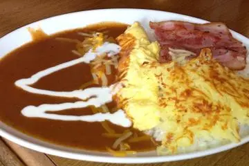 <p>The chili omelet is a cheese omelet served with rice, hash browned potatoes, bacon, rice and sour cream</p>