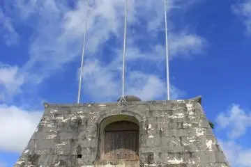 Tiang-tiang bendera stadion berada di atas sebuah gerbang batu yang terinspirasi dari Situs Warisan Dunia Sonohyan Utaki yang ada di Naha