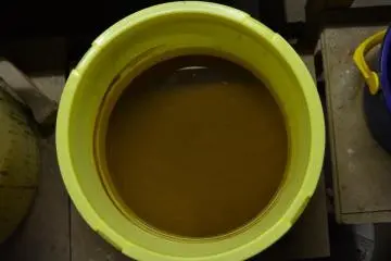 Clay glaze solution in a bucket. Pottery to be glazed is dipped in the bucket, or else painted with the glaze.