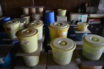 Small tubs containing different colored glazes.