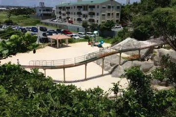 The small playground at Toguchi Beach has plenty of sand, a rock climbing wall, a slide, and a toddler jungle gym