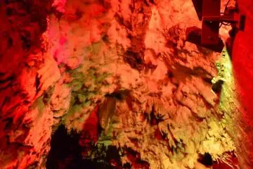 Stalactites descend from the ceiling above.