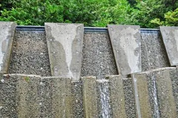 A pool of water overflowing into the stream below.