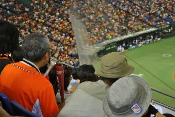 A fan clanks together noisemakers in the shape of baseball bats
