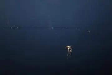 Gaze out at the eerie sea, where fisherman are still at work
