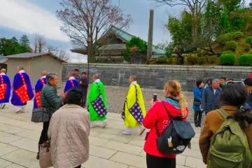 나리타산 사원의 승려가 본당을 향해 걷고 있습니다