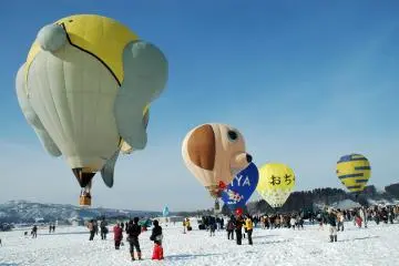 The snowy white landscape is filled with brightly colored balloons (Photo: <a href="https://upload.wikimedia.org/wikipedia/commons/6/6f/2006_Ojiya_balloon_festival_003.jpg" target="_blank" rel="noreferrer noopener nofollow">Wikimedia Commons</a> / <a href="https://creativecommons.org/licenses/by/2.1/jp/" target="_blank" rel="noreferrer noopener nofollow">CC BY 2.1 JP</a>)