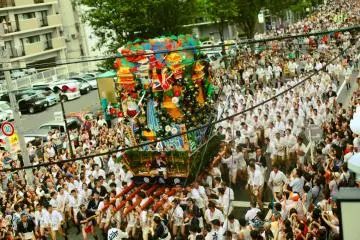 <p>เสรี่ยงสุดอลังการซึ่งแบกโดยชาย 30 คนเคลื่อนเข้ามาบนถนน</p>
