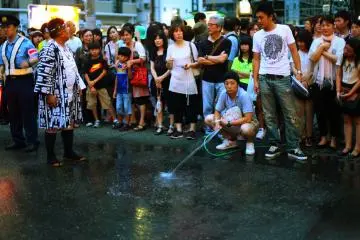 <p>ฝูงชนช่วยทำให้ถนนเปียกเพื่อเตรียมการสำหรับขบวนแห่</p>