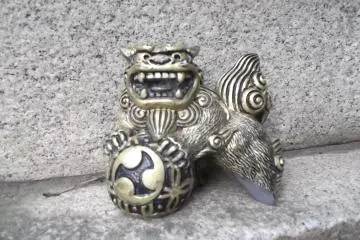 A tiny shisa Okinawan lion statuette, on a lantern I think