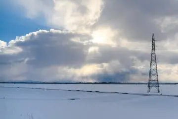 A view of the Aomori countryside covered in snow, taken from a Tsugaru Railway train