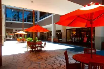 Patio-styled tables with bright red shades add a splash of color in the blue and white mall