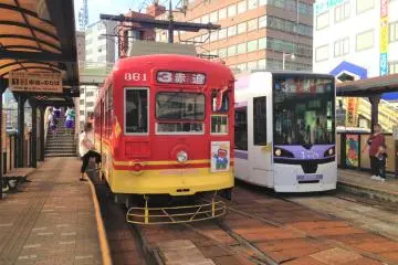 Nagasaki Eki Mae tram station (Photo: <a href="https://commons.wikimedia.org/wiki/File:Nagasaki_Tramway_cars_stopping_at_Nagasaki-Ekimae_Station.JPG" target="_blank" rel="noreferrer noopener nofollow">そらみみ (Soramimi) / CC BY-SA 4.0</a>)