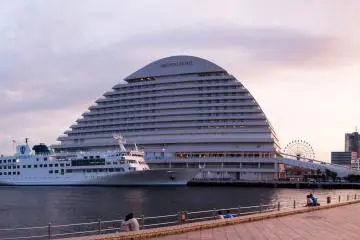 Couples sit around the water edge as the mammoth Oriental Hotel harbours the Luminous 2.