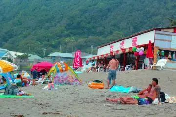 Beach goers laze around on the beach and enjoy the burn of the UV rays.