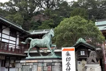 Seibo Kitamura, famous for Nagasaki's Peace Park Statue, created this vibrant horse statue in commemoration of the 60th anniversary of Emperor Hirohito's accession in 1985. Note the completely non-related signage directing visitors to the desk selling shrine seal stamps, a popular shrine souvenir.