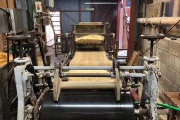Dye press machine topped with heaps of sawdust 