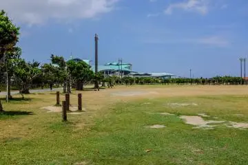 Ginowan park has a large grass field with exercise equipment surrounding the jogging track