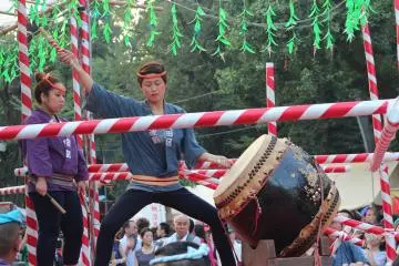 Taiko drummers perform onstage in the center of the festival grounds.