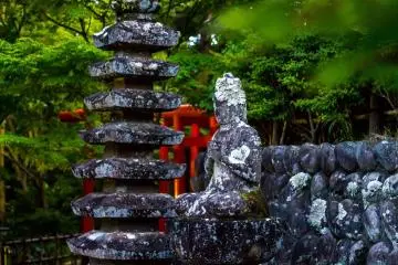 An old, carved statue of a deity and stone-carved pagoda