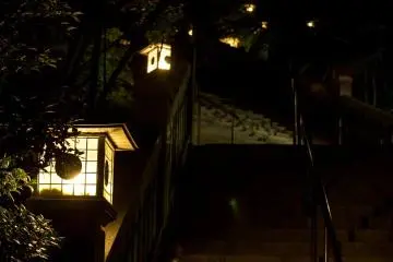 The temple steps are lit by lantern light after nightfall