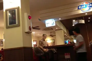 A friendly "Officer" sits at the bar greeting and taking photos with guests.