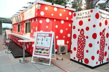 Take a photograph next to Yayoi Kusama's lifesize image.
