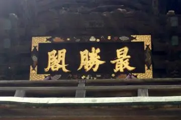 Above the gate, the kanban sign has a rebus puzzle border