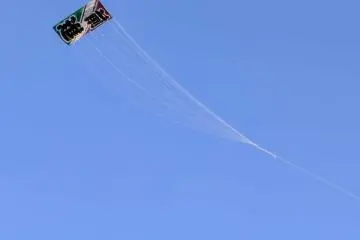 A giant kite reading “zenshin”, progress