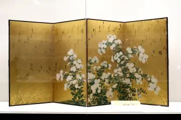 A gold folding screen background is reminiscent of the shining sun