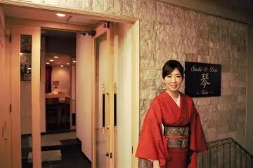 Ms. Miyuki Takeshita in front of the store entrance