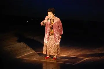 An Uchiko local performs a karaoke number at a town event.