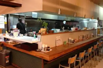 <p>The kitchen is lined with bar stools allowing patrons to see their orders prepared right before their eyes</p>