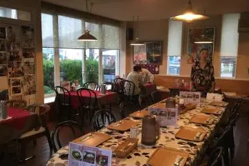 Restaurant interior and owner Akie Konishi at the head of the table.