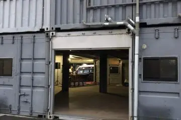 Expansive room is the 1st floor of a container block. Lonely DJ in far corner by rear door. The boarding rooms and showers are upstairs.