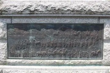 The bas-relief at the base of the statue showing the ritual hunting procession