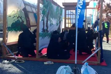 I counted 10 people behind the scenes. 