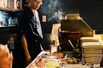 One of the chefs looks over the grill